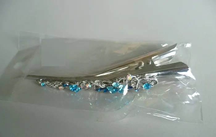 Scivolo per capelli «Haarklammer in Bananenform mit blauen Strass-Steinen» — foto 1 dell'alert INFO/00071/22